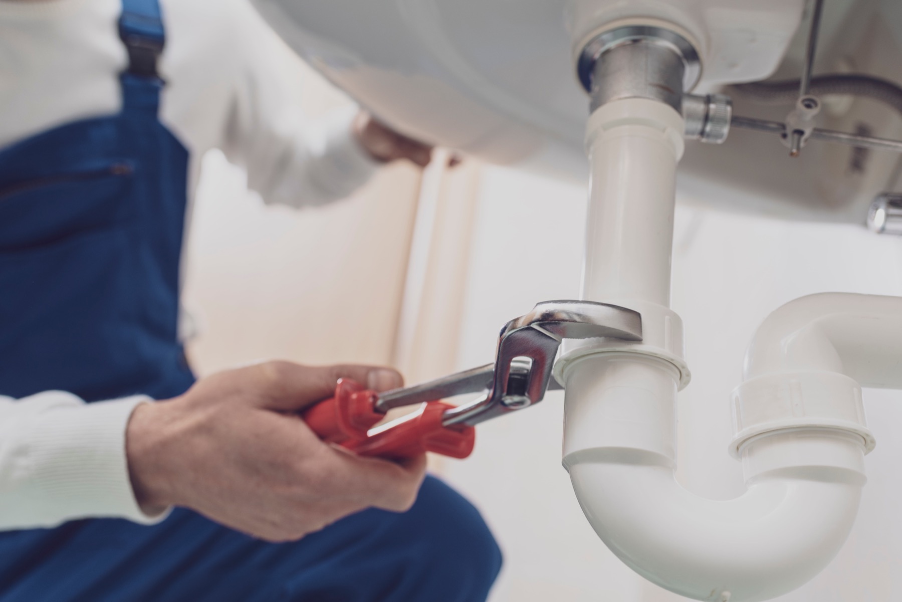 Plumber working under a sink